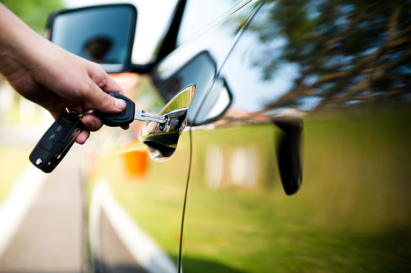 Car keys opening a car door